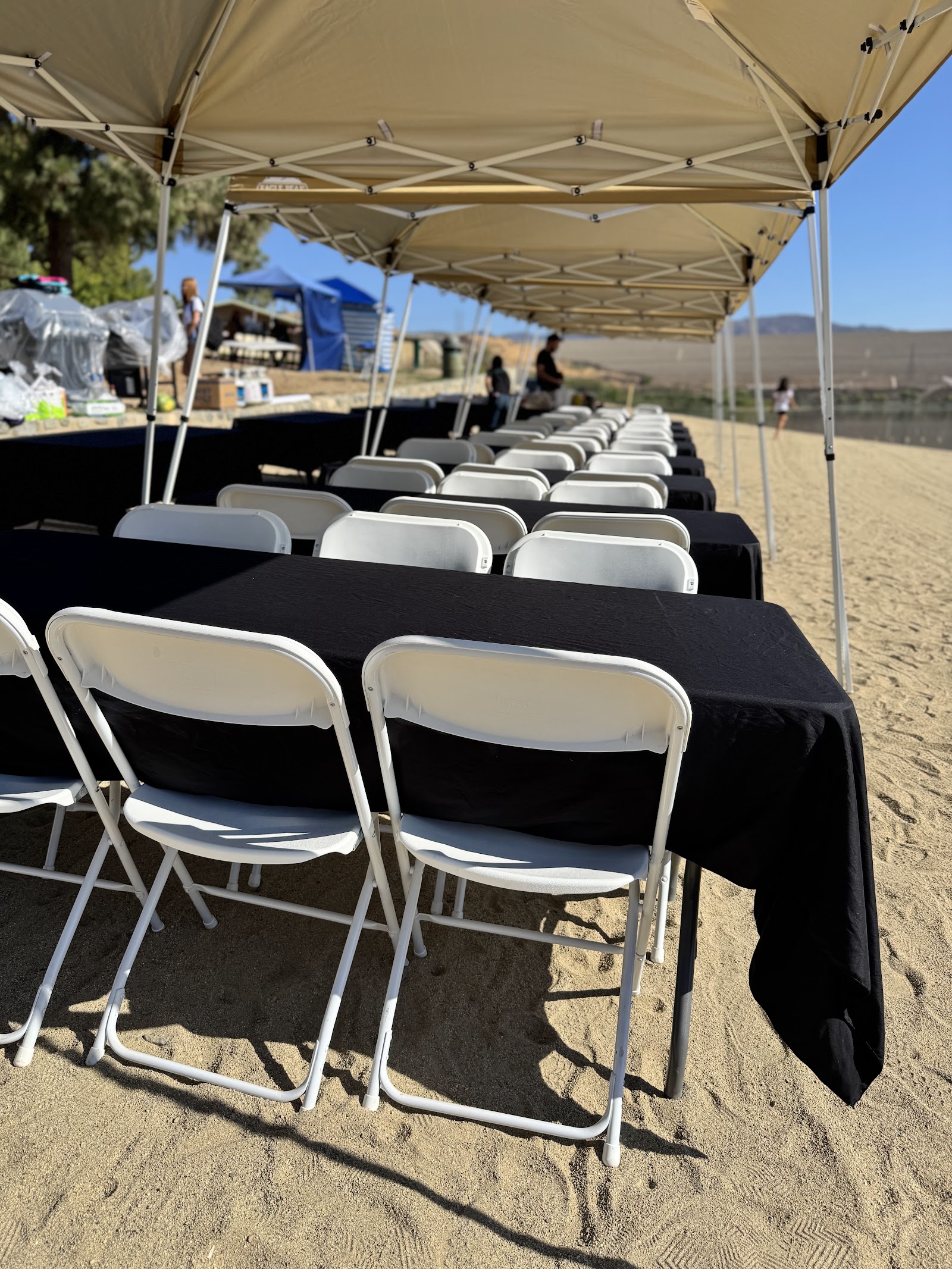 Rows of tables and chairs protected by connected pop-up tents